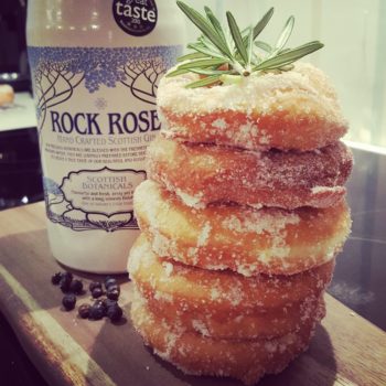 Bottle of Rock Rose Gin and Gin Doughnuts stacked up with thyme sprig on top