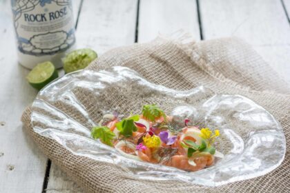 Marinated salmon served in a glass plate with edible flowers