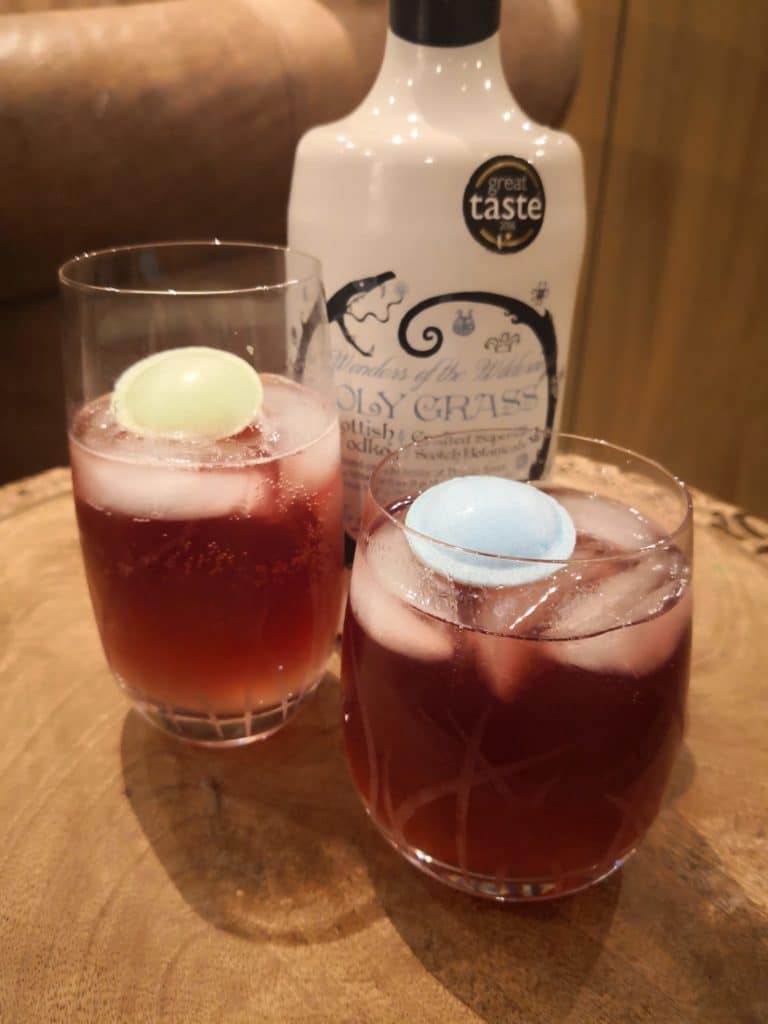 Bottle of Holy Grass Vodka and Dunnet Bay Cooler cocktail served in two glassed with ice and garnished with a flying saucer