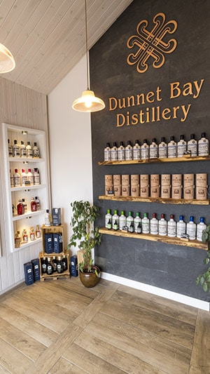 Selection of bottle on wooden shelves in Dunnet Bay Distillery Shop