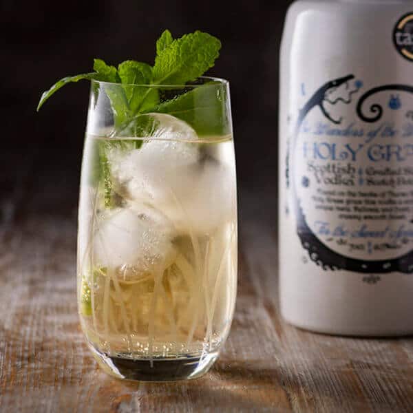 Bottle of Holy Grass Vodka and Perfect Serve in a long glass