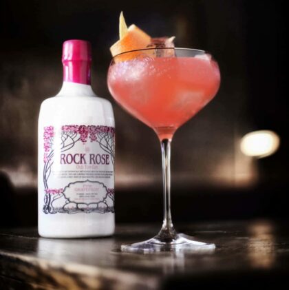Bottle of Pink Grapefruit Old Tom Gin and Sweet Old Friend cocktail served in a coupe glass