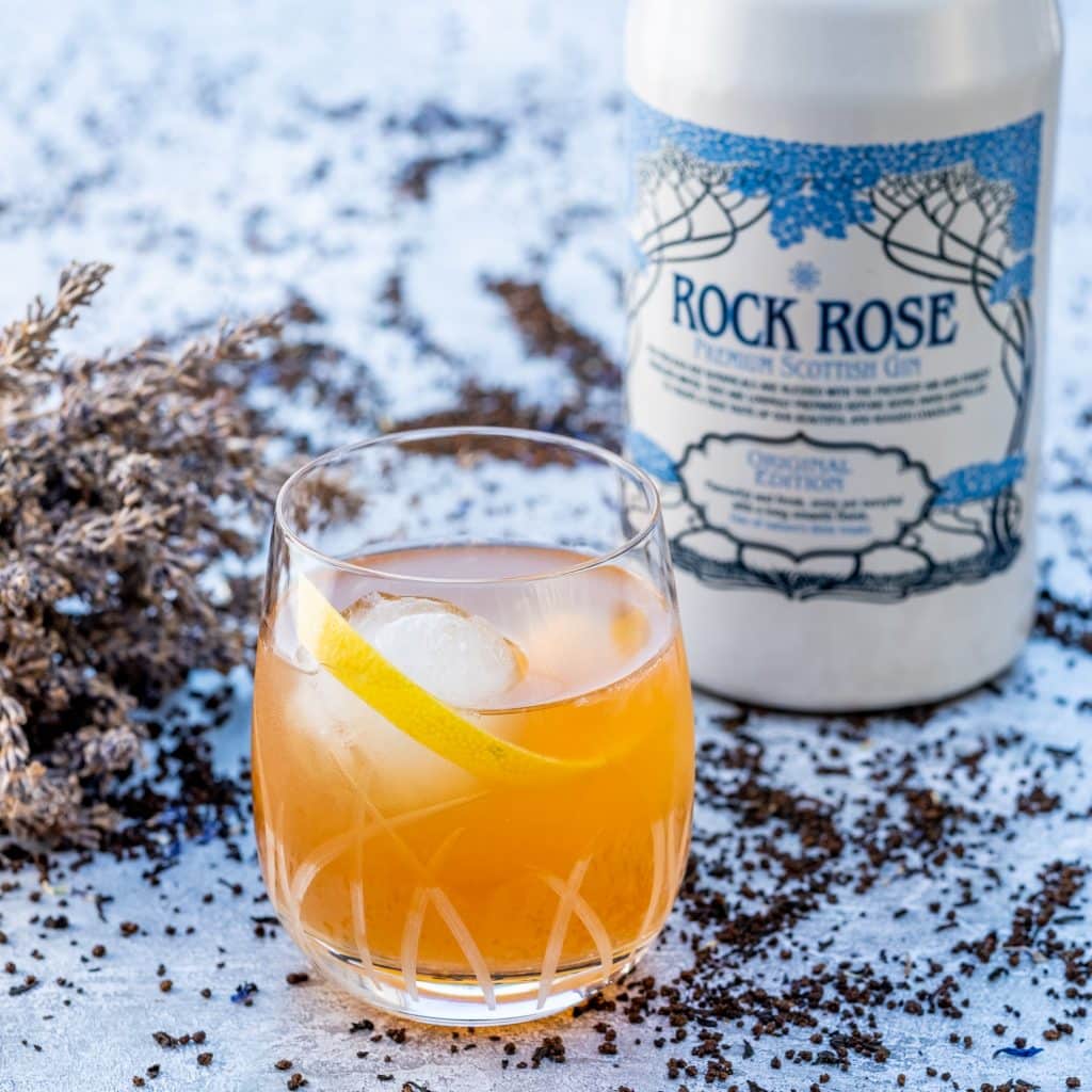Bottle of Rock Rose Gin original edition and G & Tea cocktail served with ice and garnish with orange peel