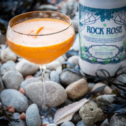 Bottle of Rock Rose Gin Citrus Coastal edition and Buckthorn sour cocktail served in a coup glass