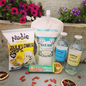 Content of the Refill Rewards Club box for July 2021 including Rock Rose Gin pouch, tonic waters, cauliflower crisps and Tony;s choco lonely bar