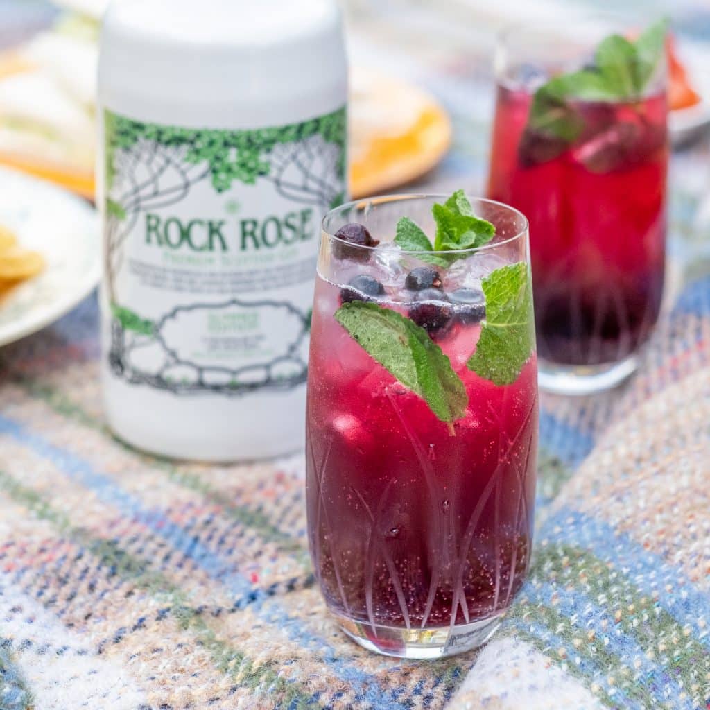 Bottle of Rock Rose Gin Summer Edition and Highland Picnic cocktail served in a tall glass