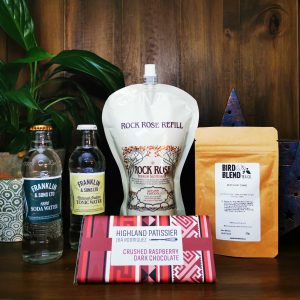 Content of the Refill Rewards Club box for October 2021 including Rock Rose Gin pouch, soda water, tonic water, birthday cake loose tea and Highland Patisserie chocolate