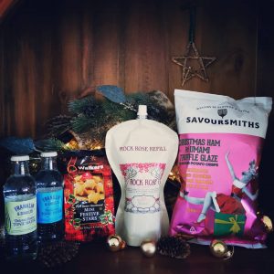 Content of the Refill Rewards Club box for December 2021 including Rock Rose Gin pouch, tonic waters. Ham and Truffle crisps and mini start shortbreads