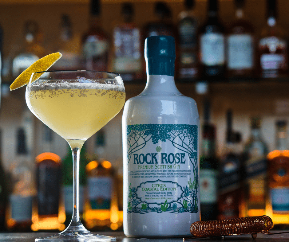 Bottle of Rock Rose Gin Citrus Coastal Edition and Ginger Lady cocktail served in a coupe glass and garnished with a slice of lemon