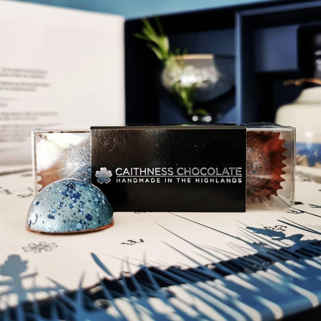 Box of Rock Rose Gin Caramel Chocolates handcrafted by Caithness Chocolate in front of Dunnet Bay Distillers Rock Rose Gin Gift Set