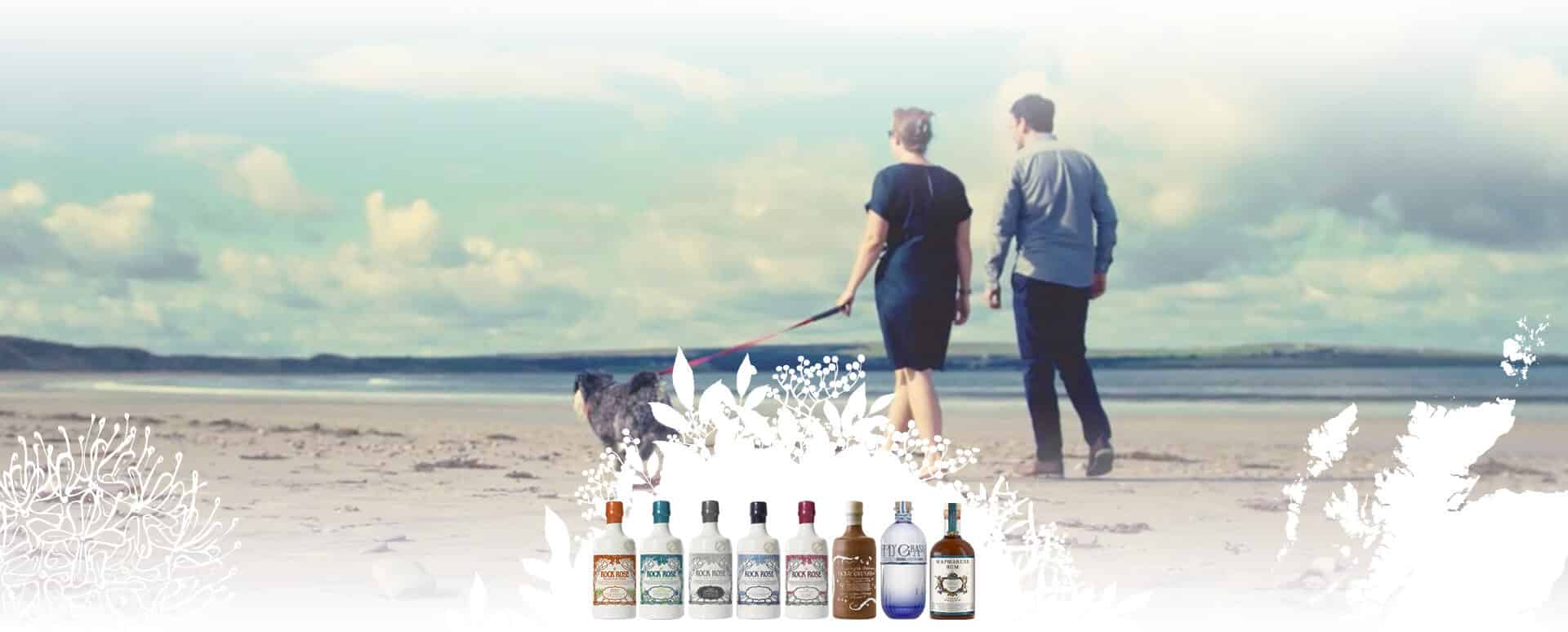 Dunnet Bay Distillers spirits bottles lined-up with Claire and Martin Murray walking with dog on Dunnet Bay beach in the background